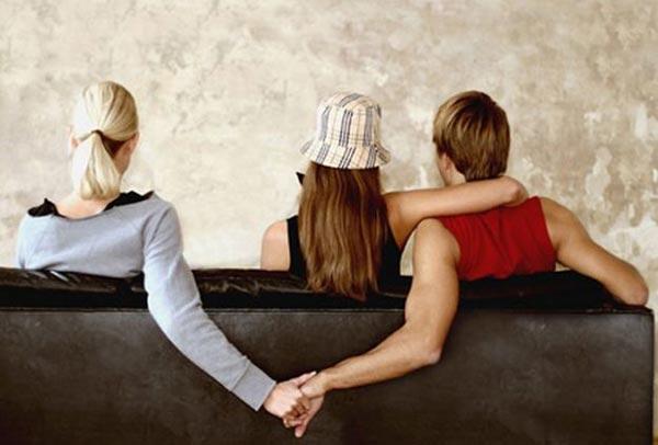 foto di uomo che tiene la mano ad una donna e ne abbraccia un'altra