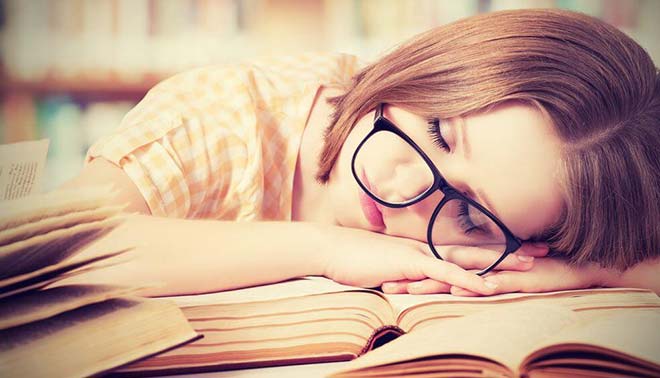 foto di studentessa stanca sui libri