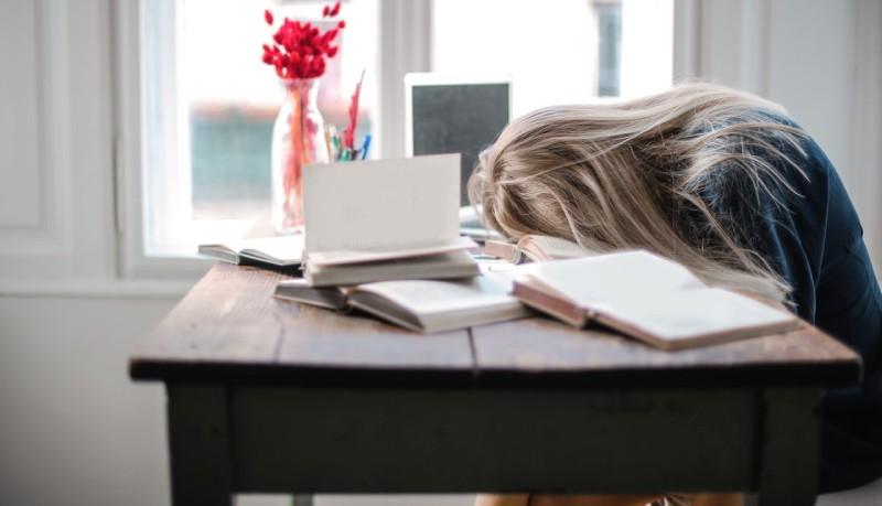 foto di studentessa che dorme sui libri