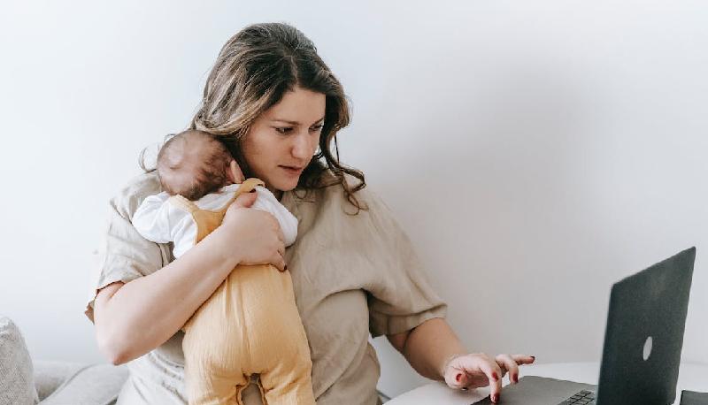 studentessa neomamma sostiene orale con figlio di sei mesi