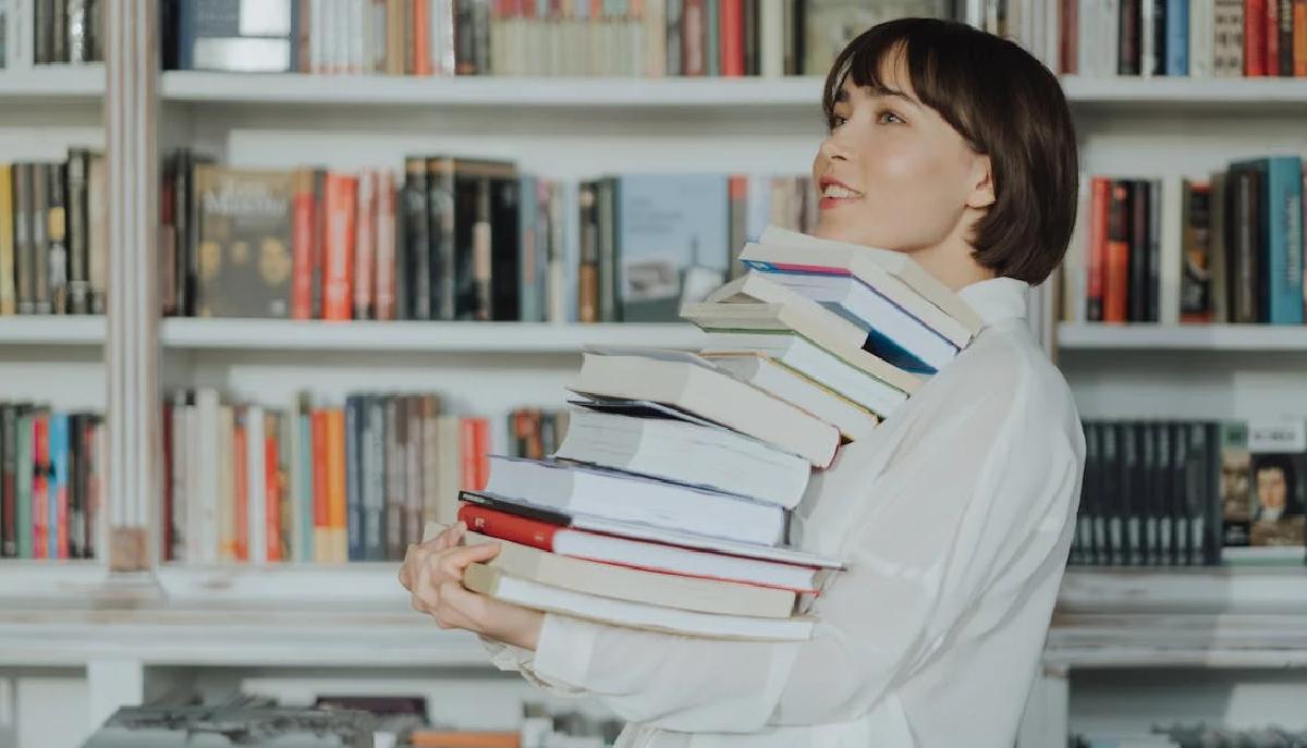 studentessa con in mano pila di libri
