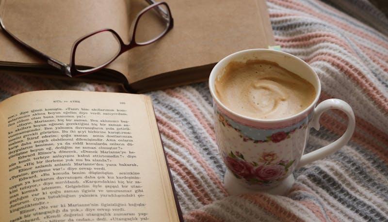 Libro aperto con cappuccino sul letto