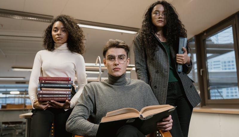 Tre studenti in aula con i libri