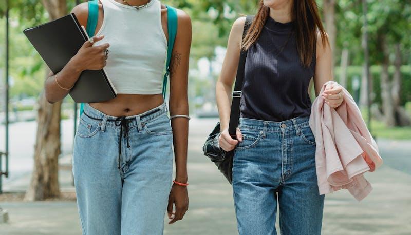 Due studentesse camminano per il cortile della scuola
