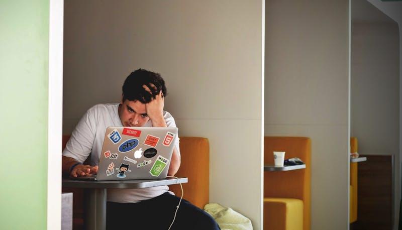 studente al computer con una mano tra i capelli