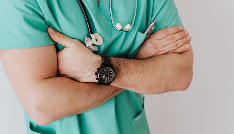 Medico con le braccia incrociate, in attesa della pubblicazione dei posti disponibili alla facoltà di Medicina