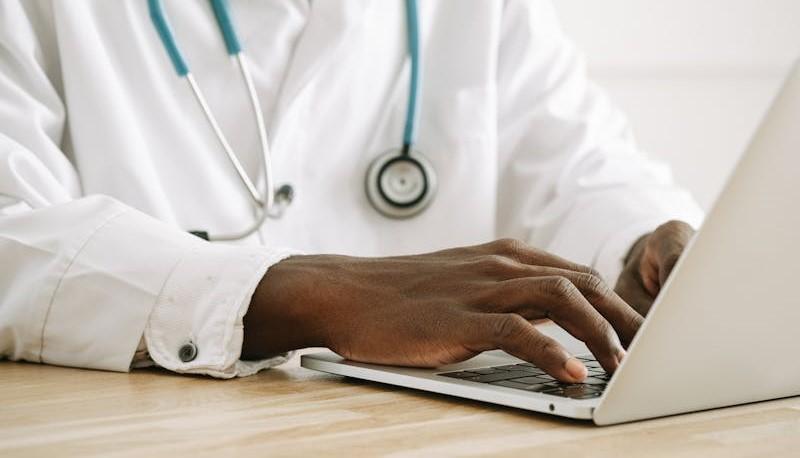 Medico al computer che consulta i punteggi della graduatoria di Medicina