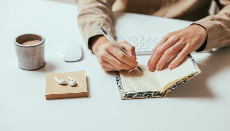 Studente si appunta su un quadernino le competenze sviluppate attraverso il Capolavoro