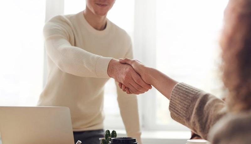 Studente stringe la mano della docente dopo aver esposto la relazione sull'esperienza di PCTO durante il colloquio orale dell'esame di Stato