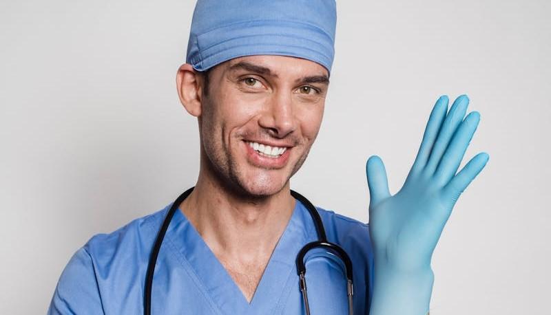 Medico sorridente che indossa un guanto