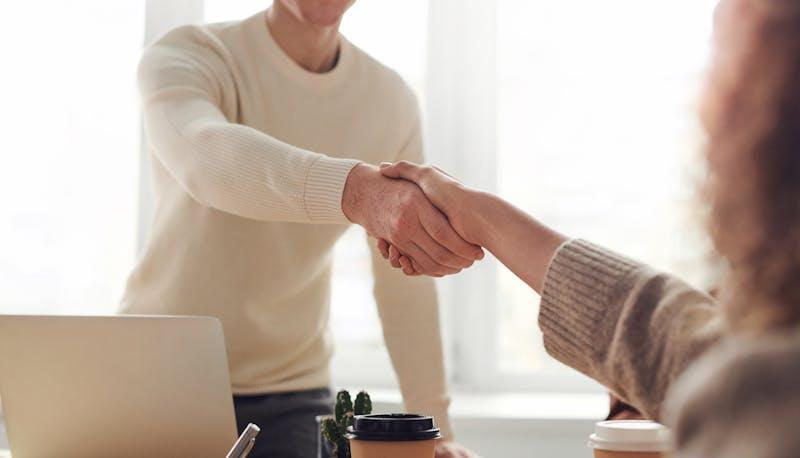Ragazzo stringe la mano al recruiter dopo aver ottenuto il lavoro dopo il colloquio