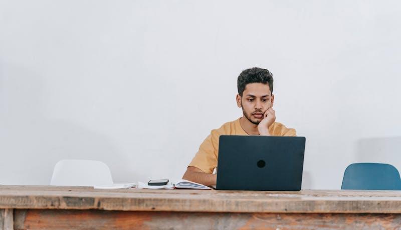 ragazzo che studia al computer attraverso la banca dati per il test di Medicina