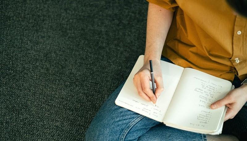 Studente scrive su un quaderno quando esce la graduatoria di Medicina 2024
