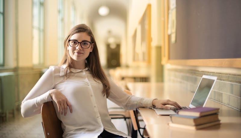 Studentessa seduta con un computer mentre si esercita per la seconda prova di Maturità di Amministrazione Finanza e Marketing