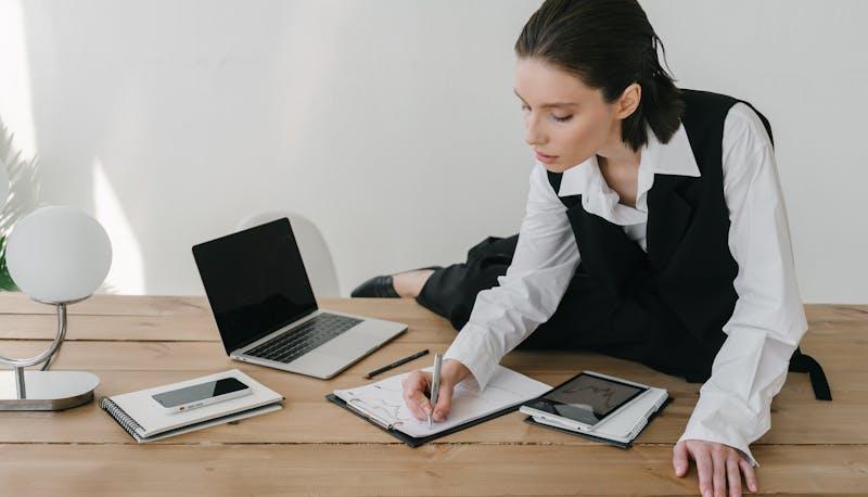 Studentessa, seduta sulla scrivania, si esercita per la seconda prova di Maturità per l'indirizzo Grafica e Comunicazione