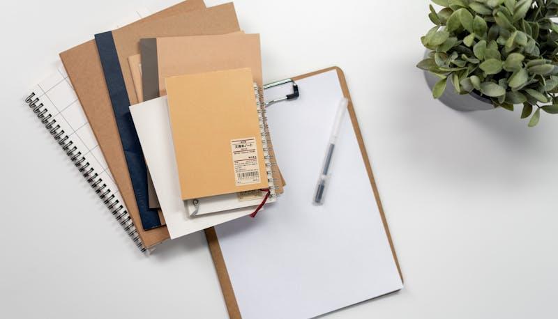 Quaderni sulla scrivania per simulare la seconda prova di Maturità per Relazioni Internazionali per il Marketing