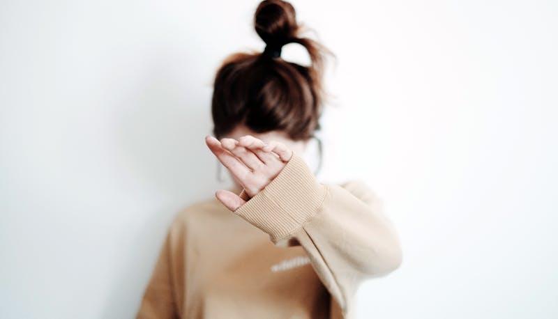 Studentessa di Medicina che si copre il viso per la paura di un esame