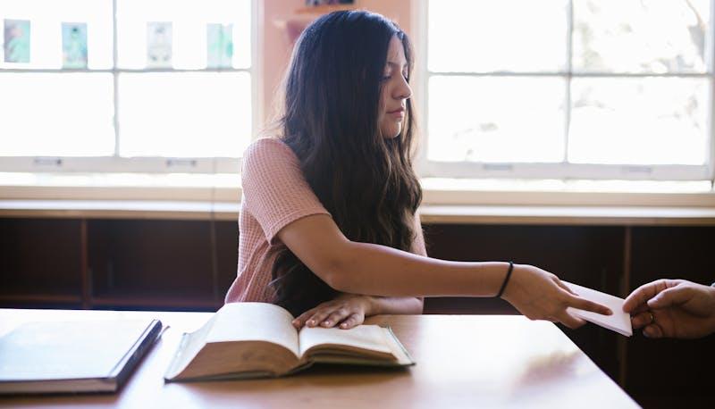 Studentessa passa un bigliettino a un altro studente durante una prova dell'esame di terza media