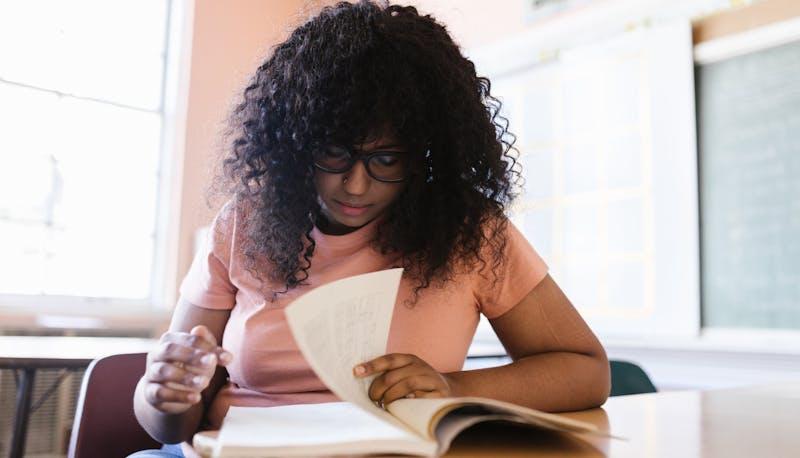 Studentessa alla prima prova di Maturità mentre cerca di sfruttare tutto il tempo a disposizione