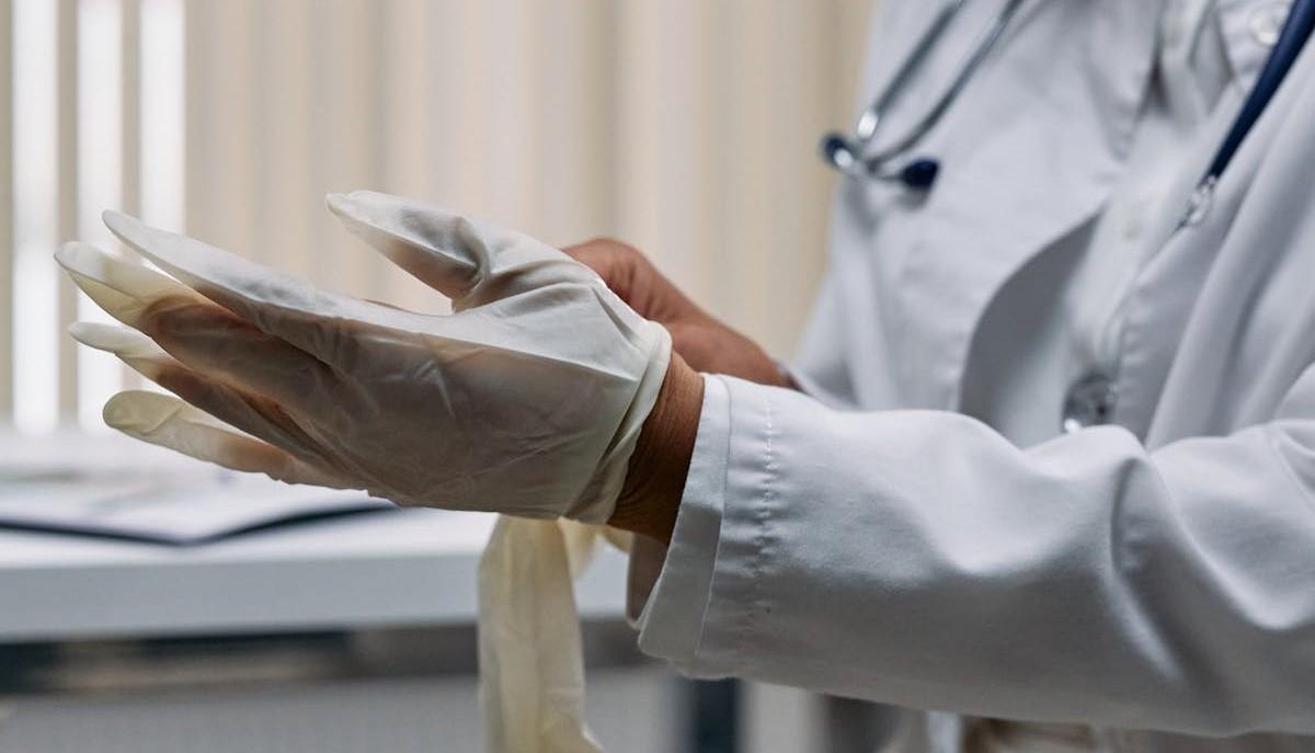 Medico che indossa i guanti