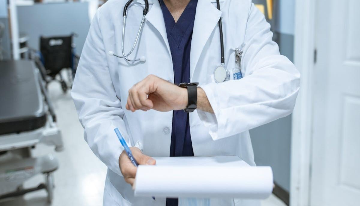 Medico che guarda l'orologio per sapere quando uscirà la graduatoria di Medicina