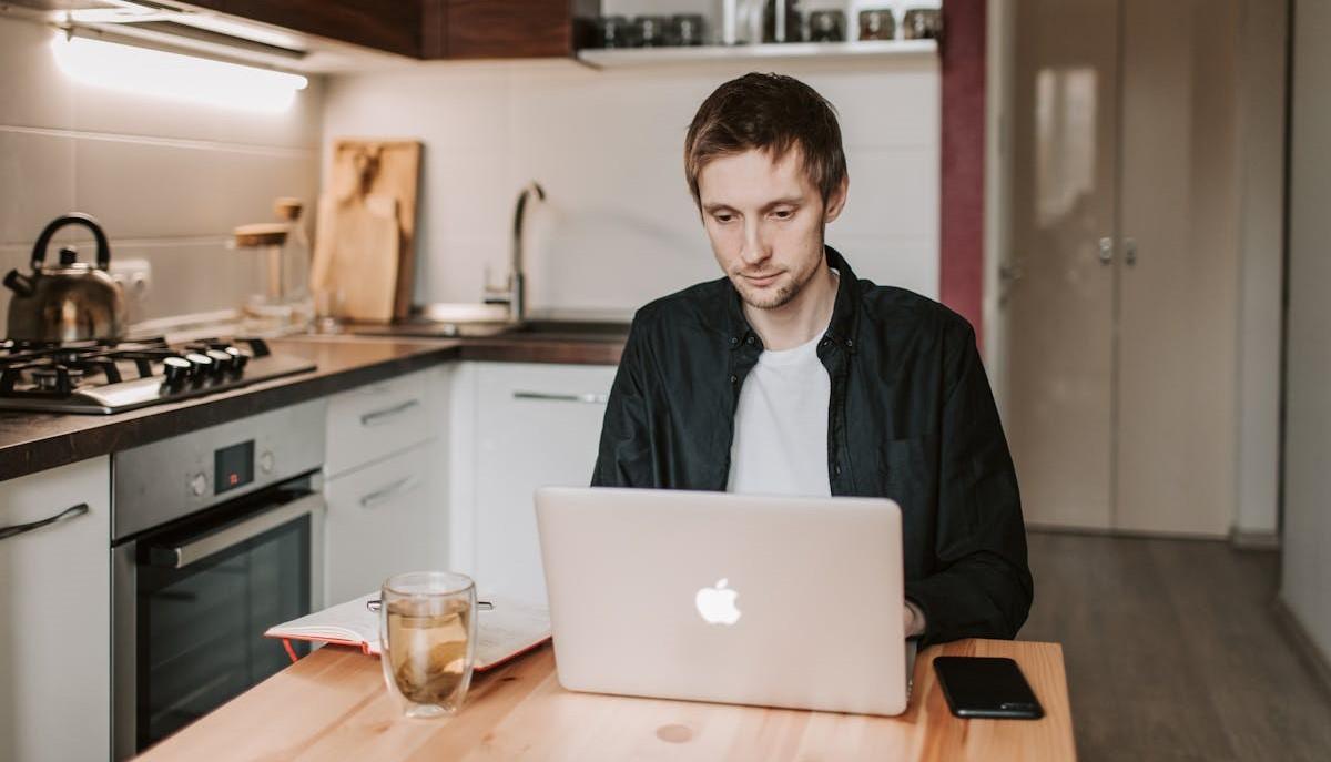 Studente al computer che cerca di capire se continuare gli studi all'università o se andare a lavorare