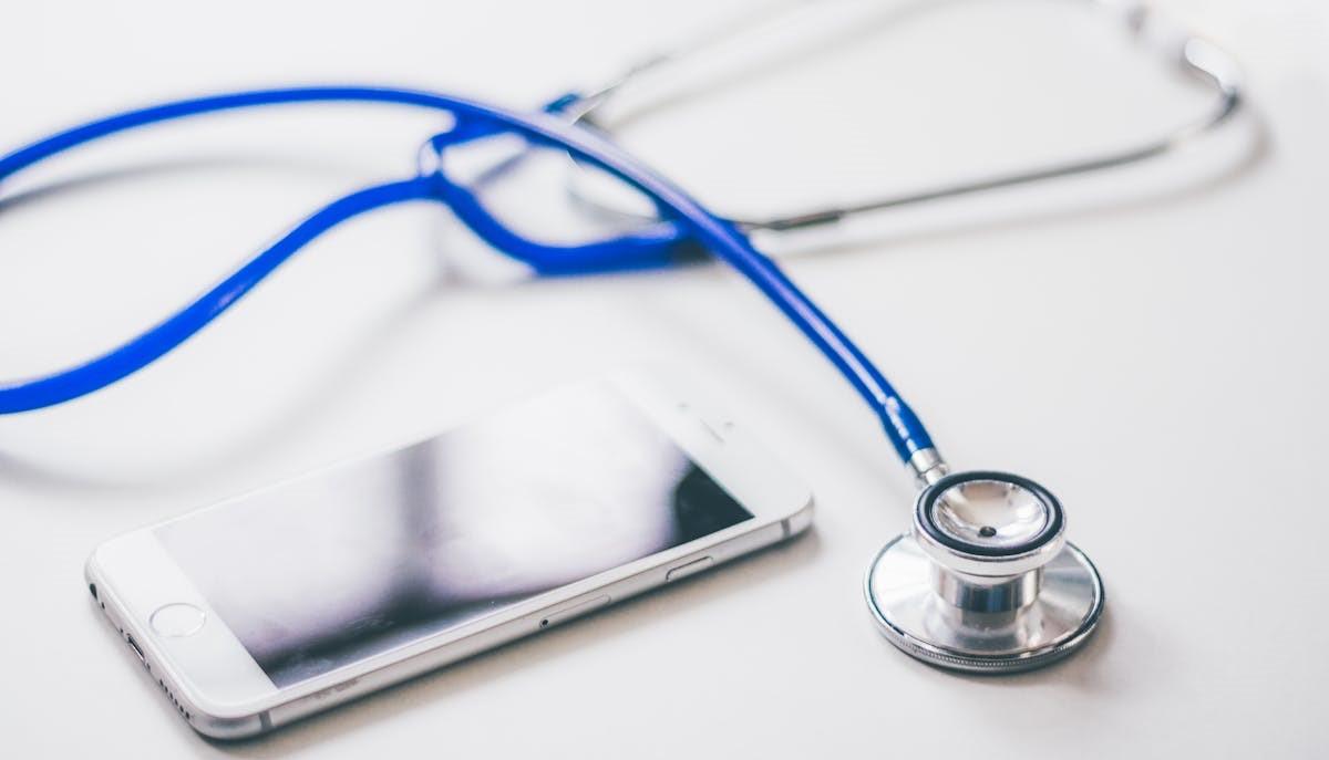 Cellulare e stetoscopio per controllare il punteggio minimo per entrare a Medicina 2024/2025 dopo la pubblicazione della graduatoria