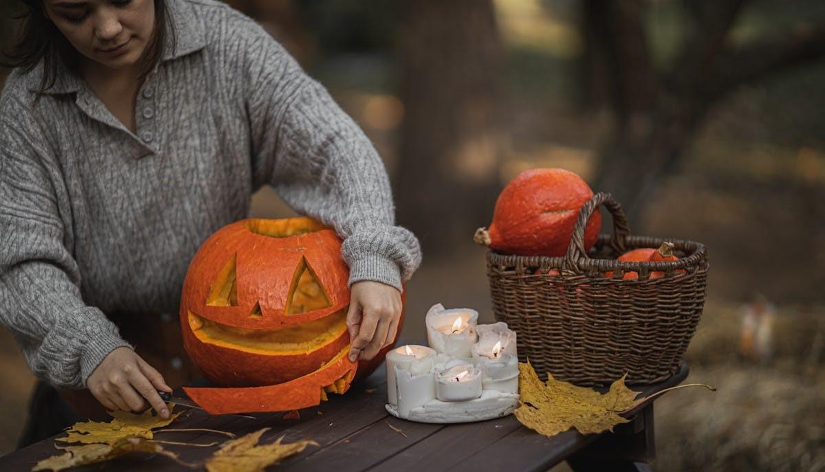 Signora intaglia una zucca di Halloween