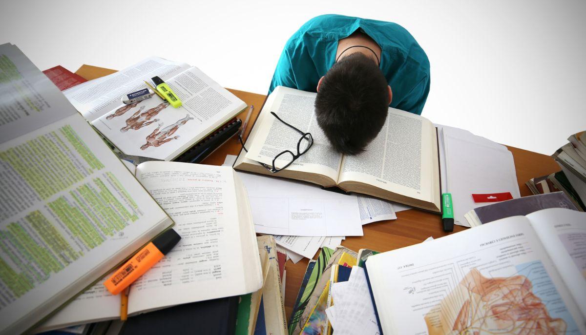 Studente delle medie con la testa sui libri perché non ha un metodo di studio efficace