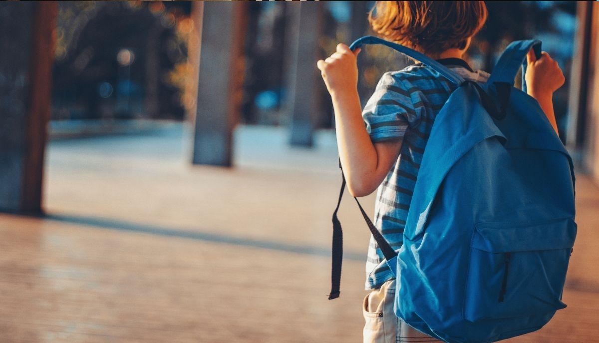 bambino con zaino all'uscita di scuola