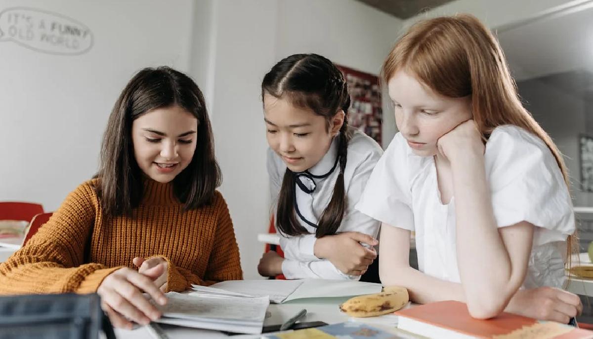 studentesse scuola media in classe leggono esercizi