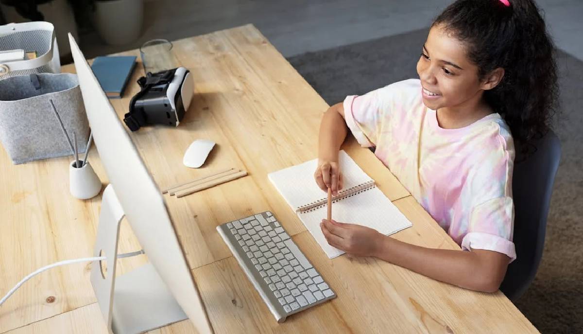 Studentessa seduta alla scrivania al pc
