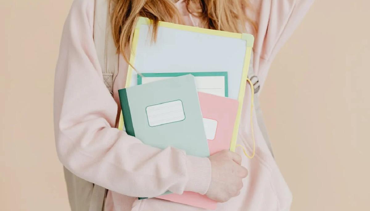 studentessa con libri e quaderni in mano