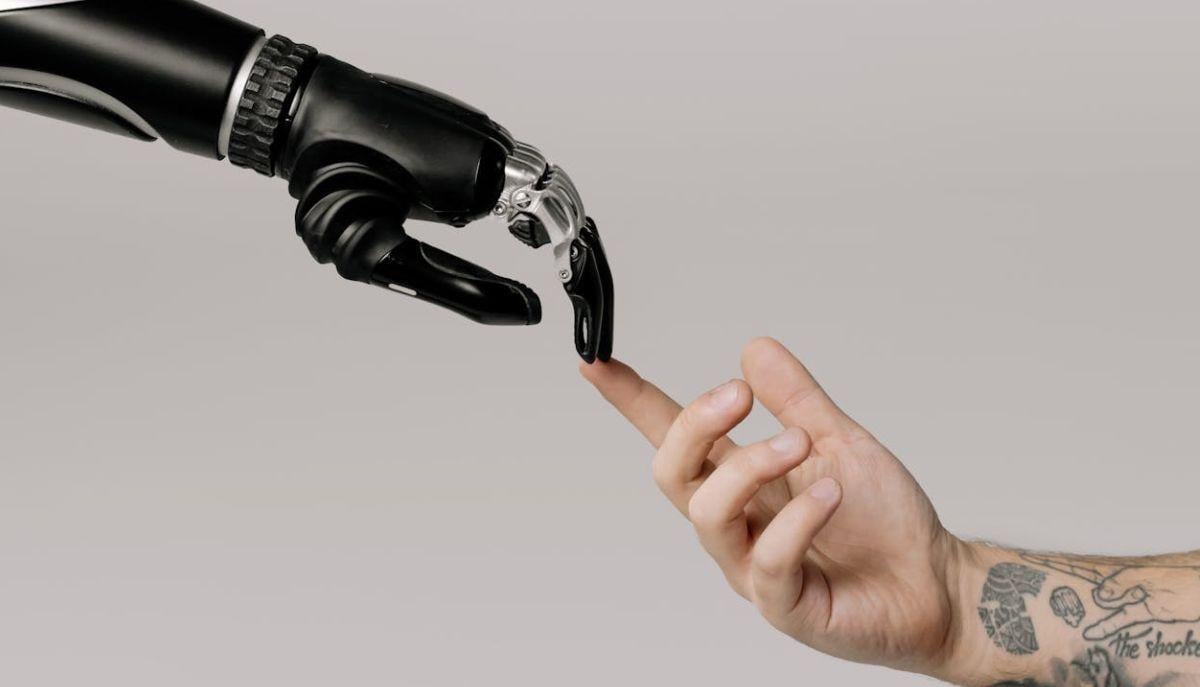 Mano robotica e mano umana che si toccano