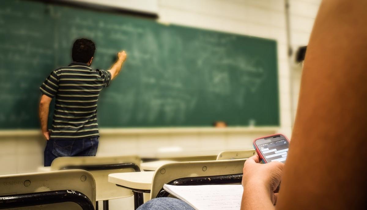 Studentessa usa smartphone in classe durante la lezione