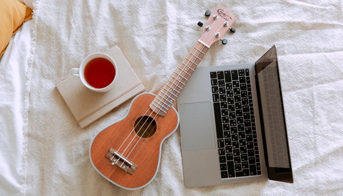 Computer, ukulele e tazza di tè