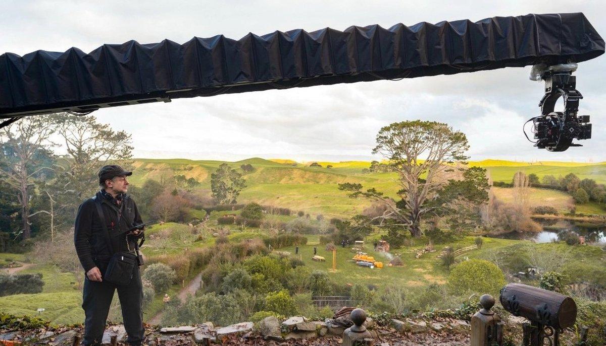 Andy Serkis controlla una gru con telecamera su un set tra colline, alberi e un laghetto