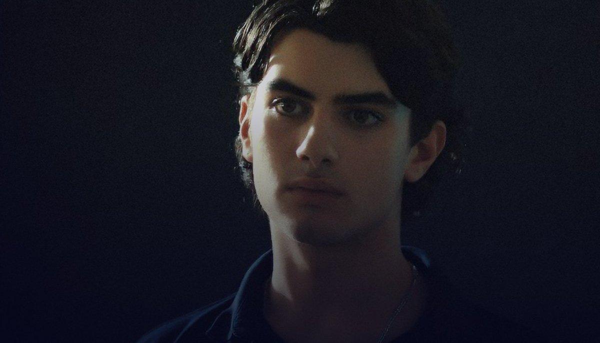 Un ragazzo guarda verso l’obiettivo con espressione seria