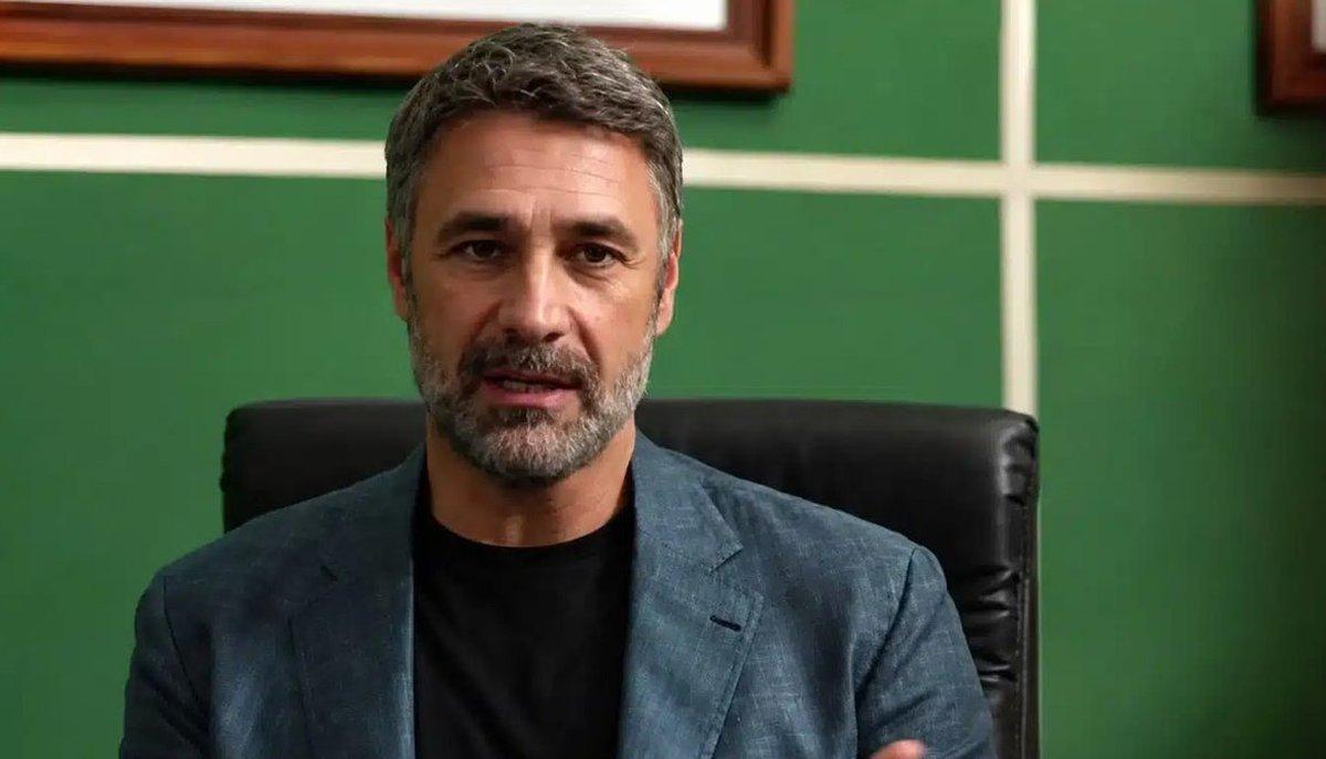 Un uomo seduto su una poltrona parla guardando davanti a sé in un ufficio