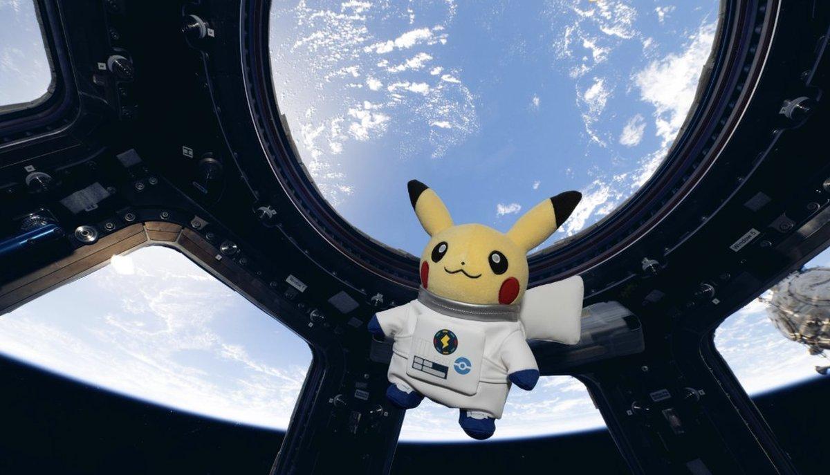 Pikachu in tuta da astronauta fluttua davanti alle finestre di una stazione spaziale sopra la Terra