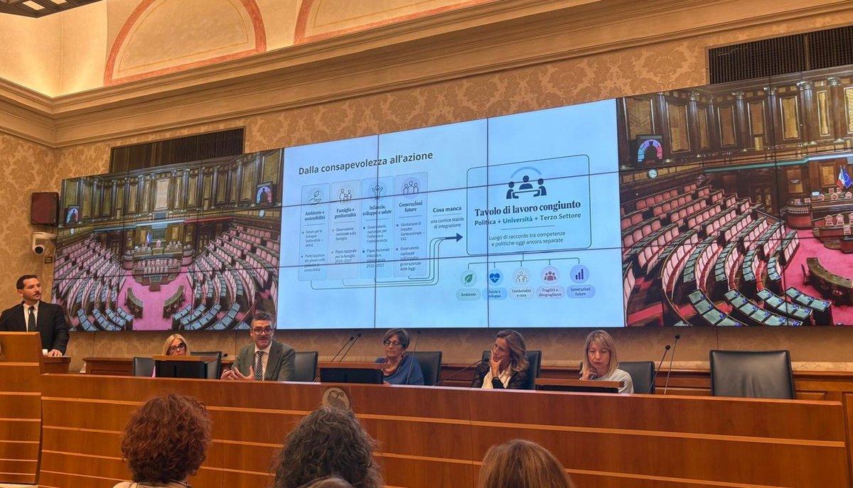 Relatori al tavolo di un convegno in Senato, con slide proiettata sullo schermo