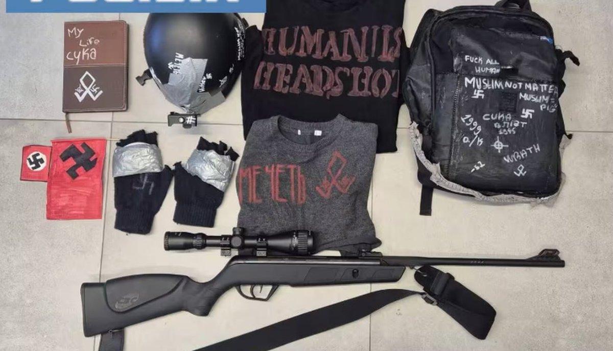 Fucile con mirino, zaino e indumenti con scritte e simboli nazisti disposti a terra